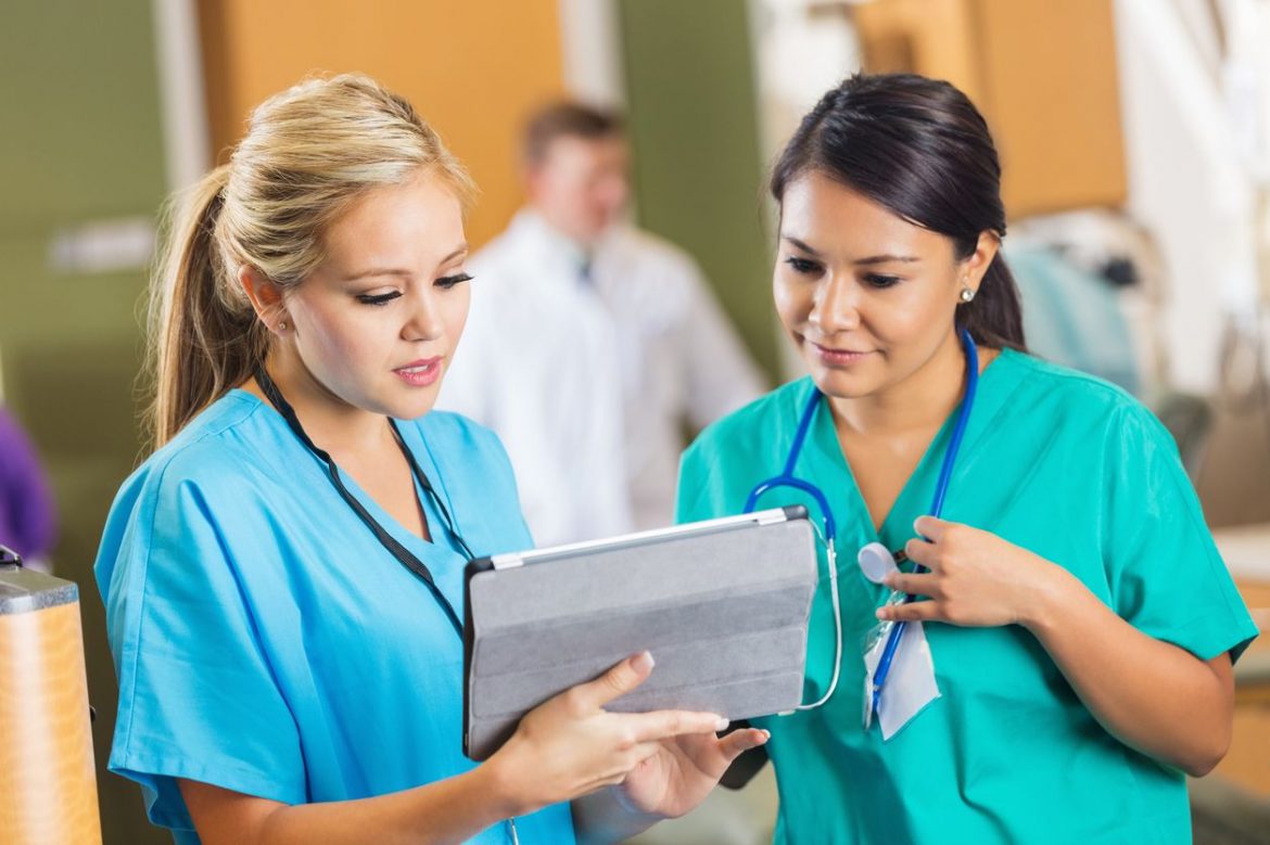 Selective focus image of two nurses using a digital tablet